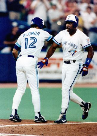 Way to go, Joe: Robbie Alomar gives Joe Carter a pat on the back after two run homer ended a personal slump and sparked Jays to 8-3 win over Oakland