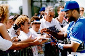 Can you see? David Wells, above, has eye test while smiling Joe Carter, left, signs autographs