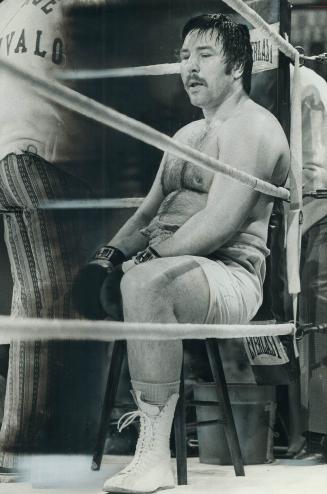 Somewhat out of fighting trim, George Chuvalo, 39, relaxes his 249 pounds in his corner during heavyweight match last night against Bobby Flestein. Ch(...)