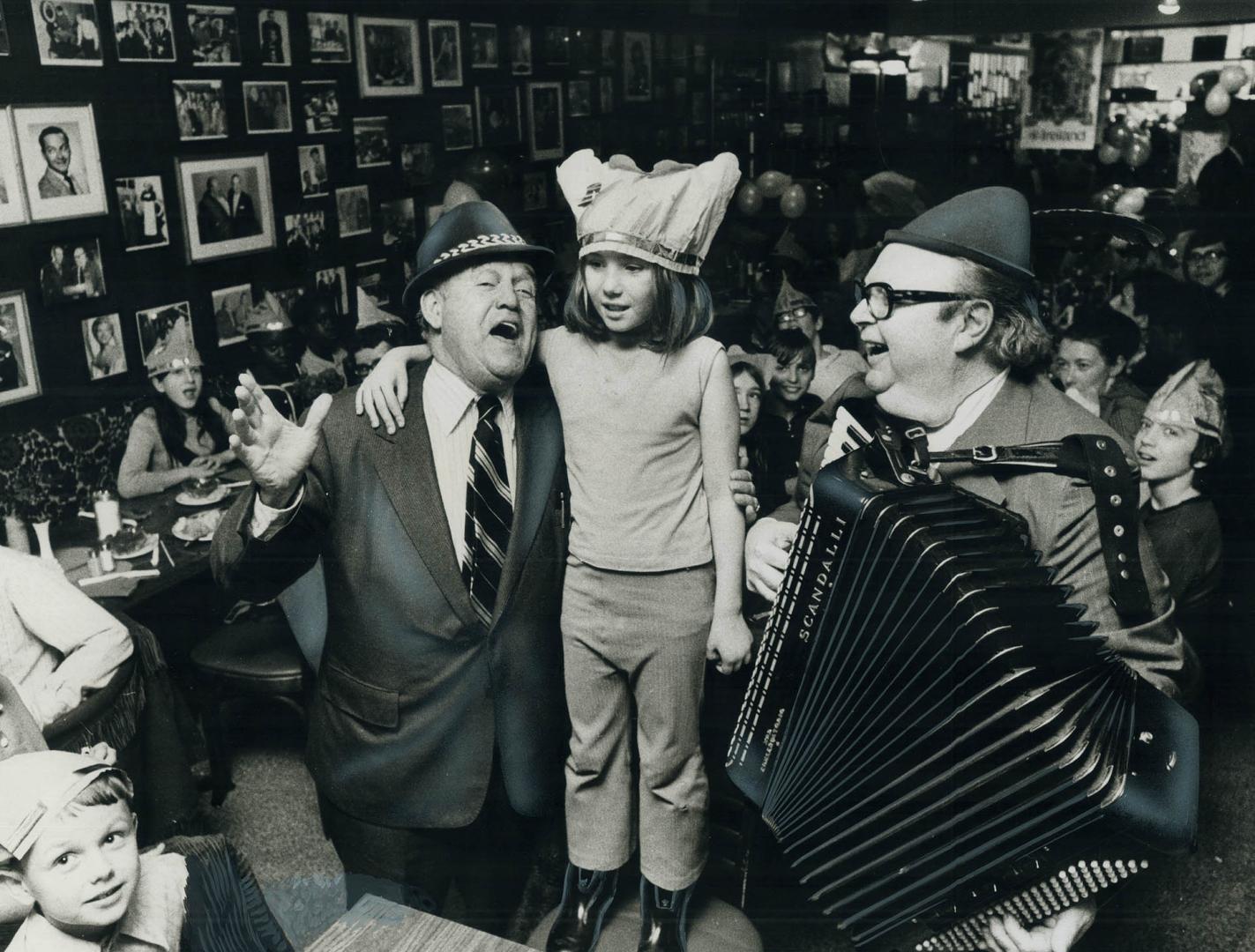 Clancy sings for St. Patrick. His voice raised in song, King Clancy, acting coach of Maple Leafs, gets admiring smile from Debbie Long, 8, of Regent P(...)