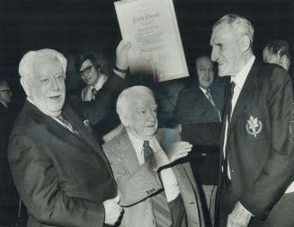 Charlie Edwards (left), former head of Broadcast News, the radio service of Canadian Press, waves the certificate naming him to the Newspaper Hall of (...)