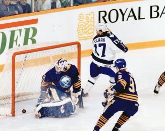 The Captain's in charge: Maple Leaf captain Wendel Clark slips the puck past Sabres goalie Daren Puppa at 31 seconds of the first period last night