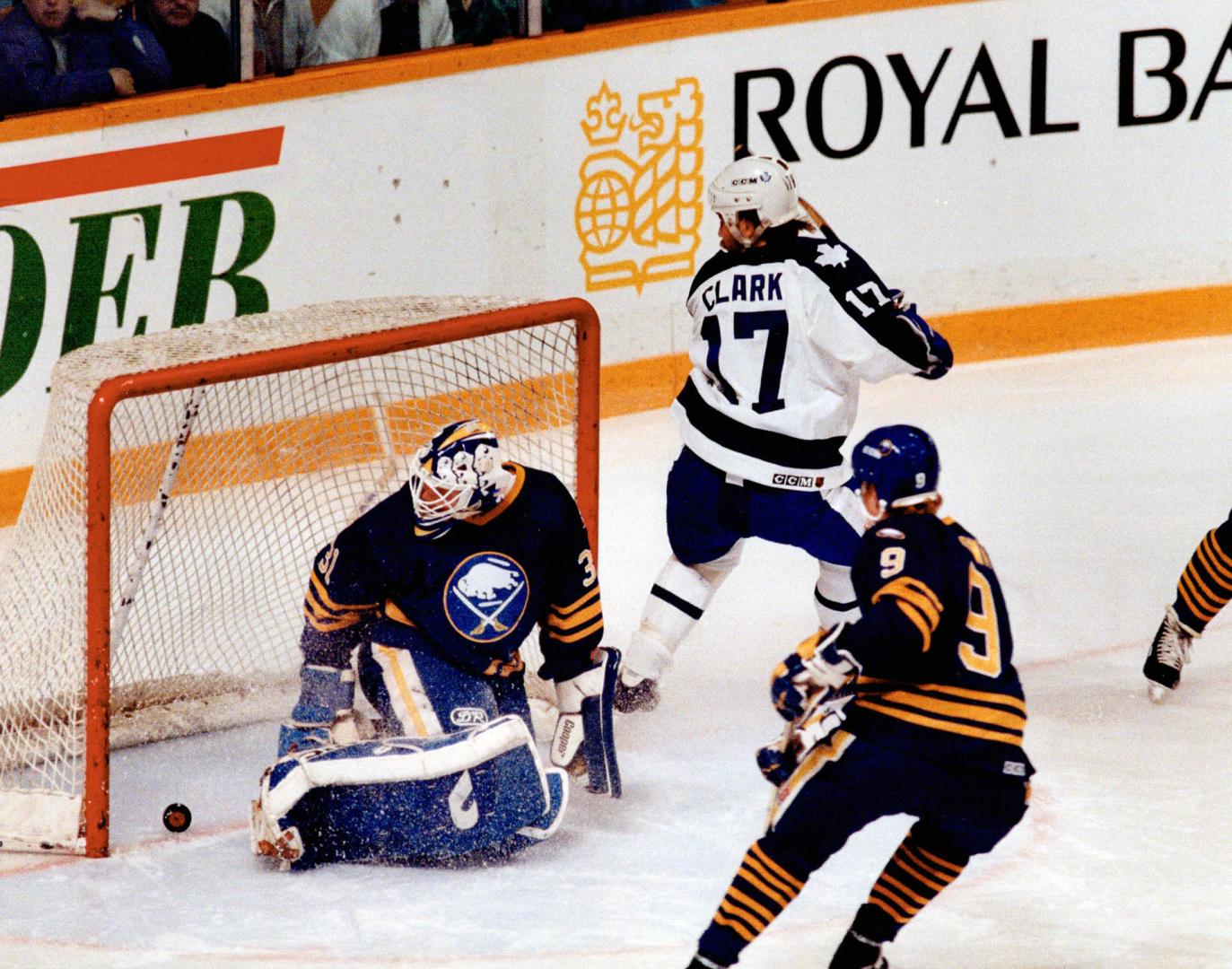 The captain's in charge: Maple Leaf captain Wendel Clark slips the puck past Sabres goalie Daren Puppa at 31 seconds of the first period last night