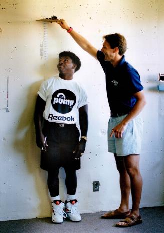 Measuring up: Mike Clemons, measured by Ralph Manning in Argo physicals yesterday, checks in at 5-foot-5 1/2, half an inch taller than last year