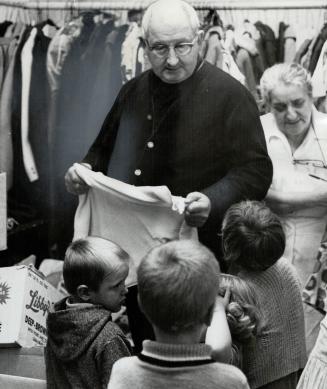 Santa Claus in a clerical collar, Brother Columban finds clothes for some of children living in the city's emergency housing hostel on Richmond St. E