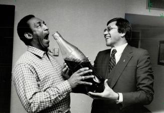 Coke challenge. Comedian Bill Cosby (left) clowns with Canadian Coca-Cola president Neville W. Kirchmann in Toronto as Coke announces new sales drive (...)