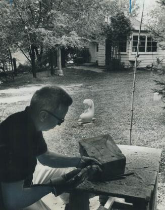 Sculptor E. B. Cox creates at his secluded residence on Finch Ave. E. Fruit trees and shrubs partly hide the wood frame house in background of picture