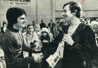 In front of throng of wordshippers, Toller Cranston (right) is congratulated by runner-up Ron Shaver at conclusion of Canadian figure skating champion(...)