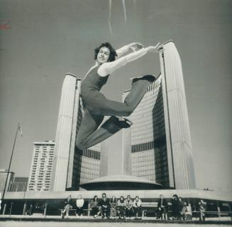 Figure skater mid air in front of Toronto City Hall