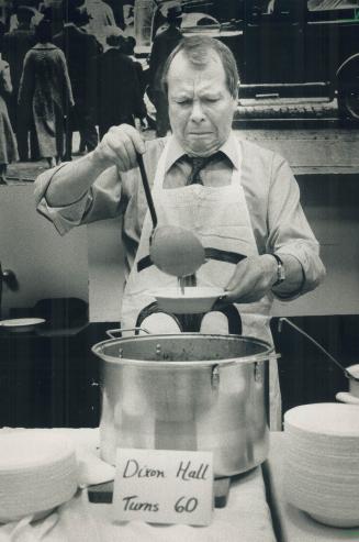 Spilled soup: David Crombie grimaces as soup splashes out of a dish as he serves it up visitors at Dixo Hall in Cabbagetown yesterday