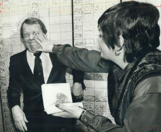 David Crombie's wife, Shirley, wipes cake from his face during victory celebration