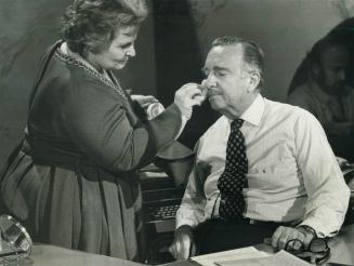Walter Cronkite. reluctantly submits to a make-up session before facing the largest television news audience (80 million) in the U.S