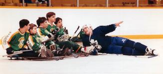 Toronto Maple Leaf defenceman Brian Curran gets down to hockey talk at the Gardens yesterday with the sledge hockey team from the Hugh MacMillan rehab(...)