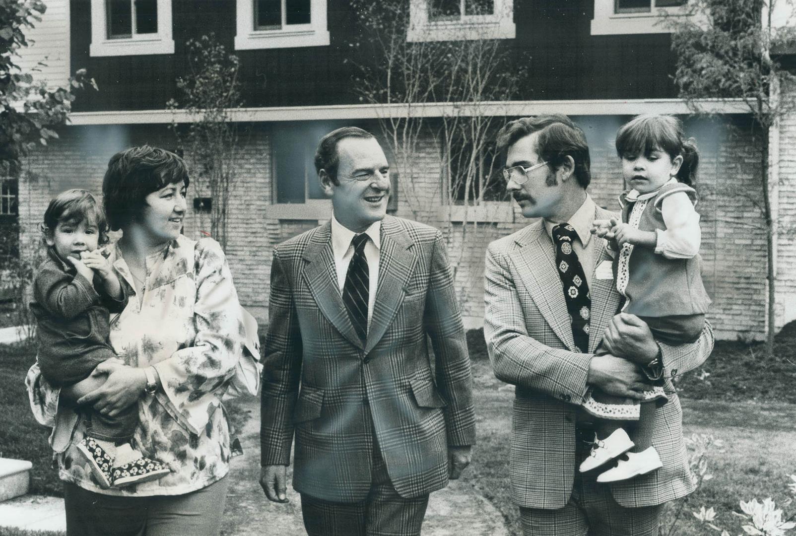 After the ribbon-cutting, Urban affairs Minister Barney Danson (middle) chats with Jim and Chris Verrall, holding their children, in front of their ne(...)