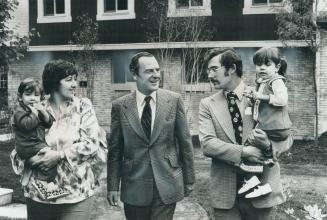 After the ribbon-cutting, Urban affairs Minister Barney Danson (middle) chats with Jim and Chris Verrall, holding their children, in front of their ne(...)