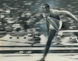 Just a blur: U.S. Olympic champion Willie Davenport lives in a world of runs. He is shown going over hurdle in streaking to world record seconds in 50(...)