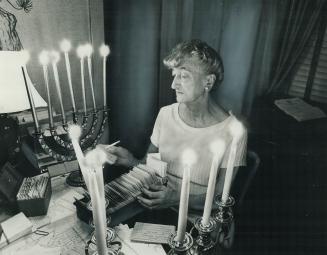It's really quite lovely, says East York Mayor True Davidson as she works away on a civic invitation list by the light of a dozen candles in her home,(...)