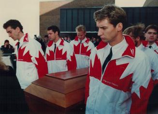 Pallbearers in their swim team jackets carry Victor Davis' coffin yesterday at his Guelph funeral