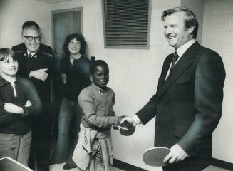 Premier William Davis shakes hands with Martin Thompson, 11, his partner at ping-pong in Regent Park yesterday