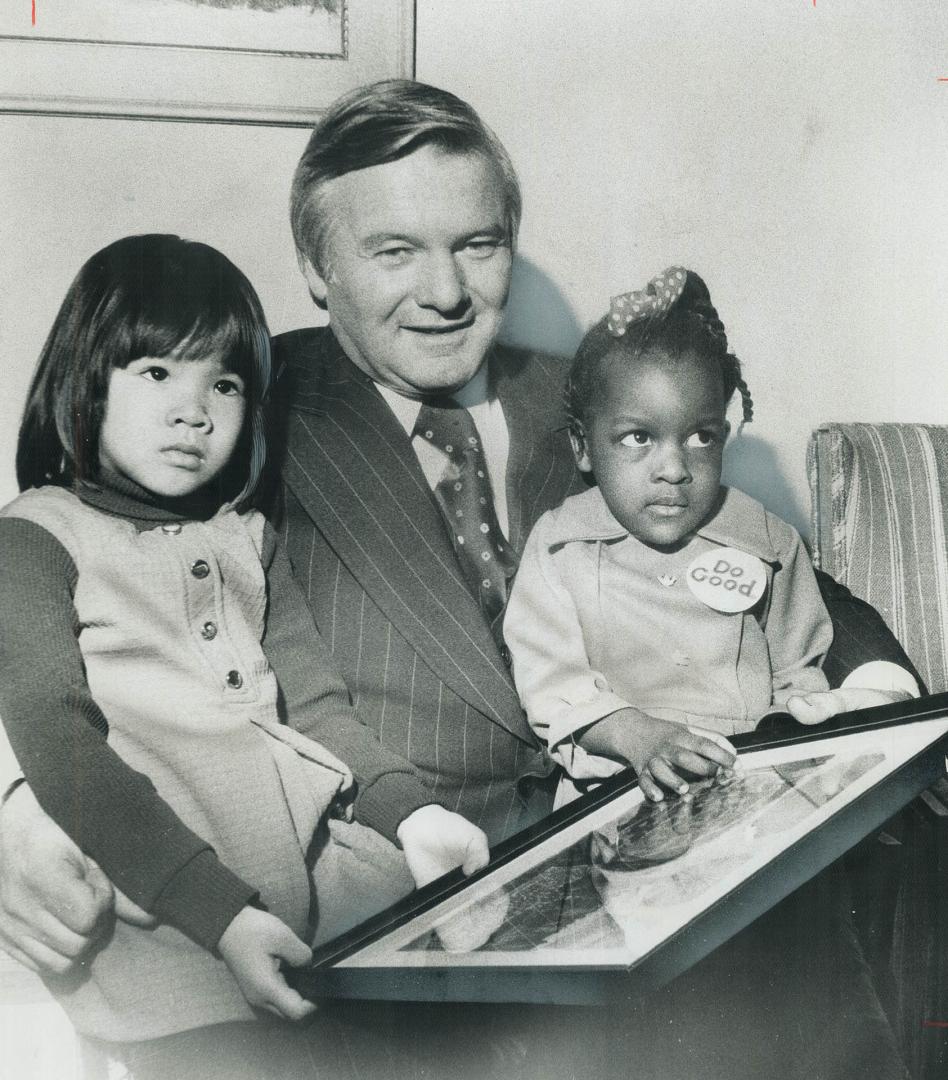 A Painting by a child was given to Premier William Davis yesterday by Karen Chan, 4 (left), of Don Mills, and Sheryl Yearwood, 3, of Scarborough, who (...)