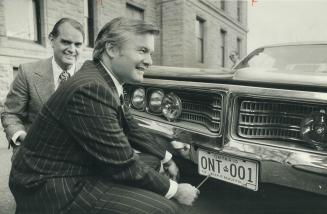 Premier gets the first plate. Premier William Davis puts the first 1973 Ontario license plate on his car at Queen's Park. For the first time, Ontario (...)