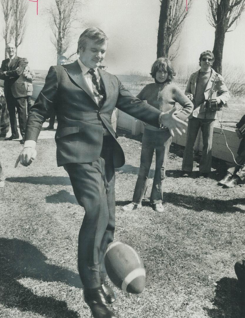 Premier William Davis takes a kick at a football on Toronto Island yesterday, where he had lunch and conversation with 140 children at the nature scho(...)