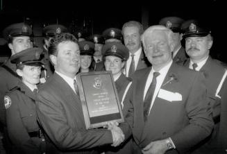 Survivor. Detective Larry Dee is congratulated by Chief William McCormack after getting the Police Officer of the year award last night. Other finalis(...)