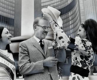 Mayor gets a cowgirl hat. As Elaine Crocco, Miss Italia West Toronto, looks on, Josephine Biondi, Miss Italia Canada of 1968, helps Mayor William Denn(...)