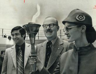 A torch lit in Israel. While Mayor William Dennison watches, Wilma Brooks of the Toronto office of E1 A1 Airlines holds Torch of Independence at speci(...)