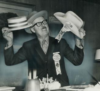 Making an executive decision, Toronto's Mayor William Dennison weighs the merits of wearing a Calgary Stampeder stetson, (right) or a Montreal Alouett(...)