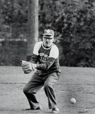 Dennison on the diamond. Eyes firmly closed, Mayor William Dennison reaches to his right while the ball goes his left in a softball game between City (...)