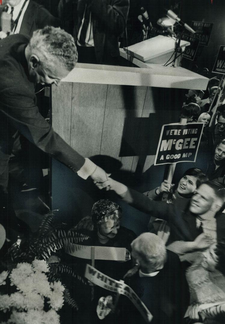 That old dief 'Magic. Reaching down form the platform, Opposition Leader John Diefenbaker shakes hands with some of the more than 7,000 persons who pa(...)