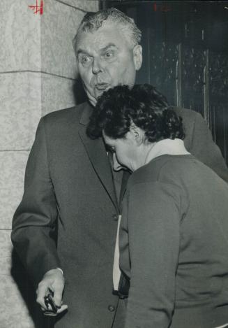 Collision! Prime Minister Diefenbaker, rushing from office to House seat, collides with a woman rushing for Commons gallery to witness voting
