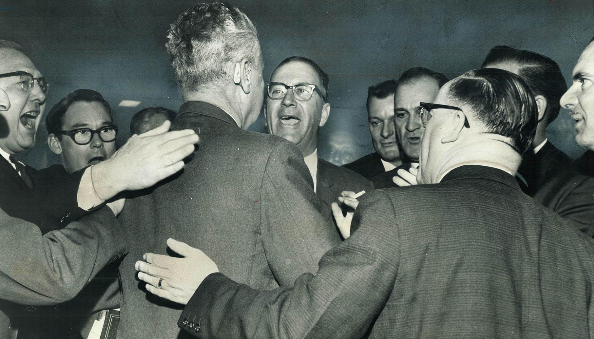 Back-Slapping Backbenchers give Prime Minister Diefenbaker a cheery welcome as he arrives at the House of Commons yesterday. However, proceedings were(...)