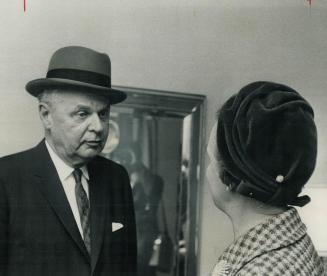 Mrs. D. Buys new hat for chief. Mrs. John Diefenbaker went shopping in Toronto today, and is shown looking over the result-a new hat for the Conservat(...)