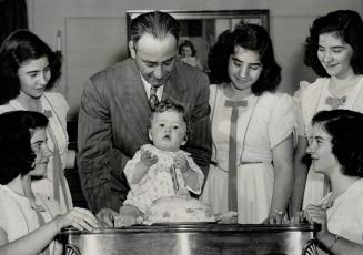 Special pride of Dionne quintuplets is Joseph, youngest member of the Dionne family shown as he pauses in effort to his birthday cake. Grouped about h(...)