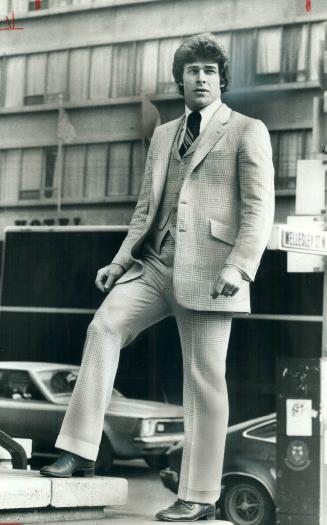 Jim Dorey, a defenceman with the Toronto Toros, models a lightweight flanel checksuit featuring a vest with lapels