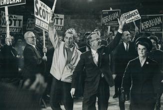 NDP Leader Tommy Douglas and wife, flanked by enthusiastic followers, entering maple leaf gardens for last night's rally. Some 12,000 shouting, stream(...)