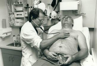 Tables turned. Metro ambulance driver Wayne Dufty, 41, gets clean billl of health from Dr. Isser Dubinsky after inhailing chemical fumes on the job