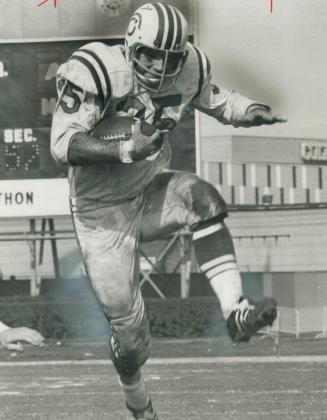 An Awesome sight for enemy defenders is Alouettes' huge fullback, Dennis Duncan, shown here in full flight