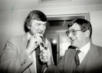 Need a light? Al Eagleson, right, lights a cigar for Team Canada coach Pat Quinn before the team headed off for world hockey tournament in Europe. Canada faces West Germany on Saturday
