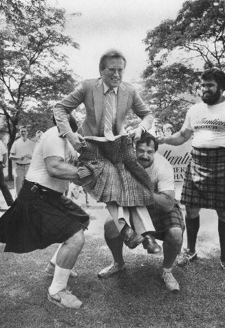 A fellow could get kilt! This event in preparation for the Fergus Highland games tomorrow is called tossing in the mayor and is performed by two heavy(...)