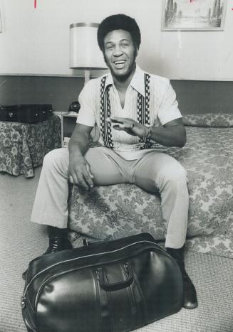 Stranger in town: Jimmy Ellis relaxes in hotel room on his arrival in Toronto for upcoming bout with George Chuvalo next Monday at Maple Leaf Gardens