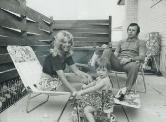 The Ellis family, Jan, 20 month old Kathleen and Ron relax on patio of their Peel Village home