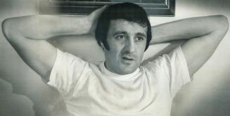 Phil Esposito of the Boston Bruins leans back and relaxes in his hotel room