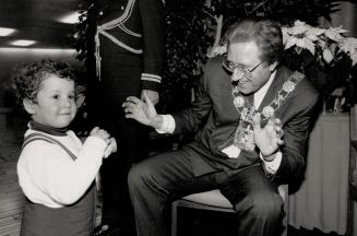 Hamming it up: Mayor Art Eggleton mugs for the toy camera of 2 1/2-year-old Jonathan Schwartz at the mayor's New Year's levee at Toronto City Hall yesterday