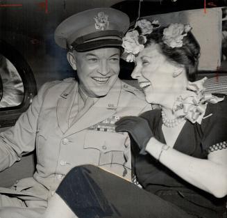 Ike and Mamie, his wife, leaned against each other smiling in the rear of the car that took them to luncheon at University of Toronto's Hart House during his visit