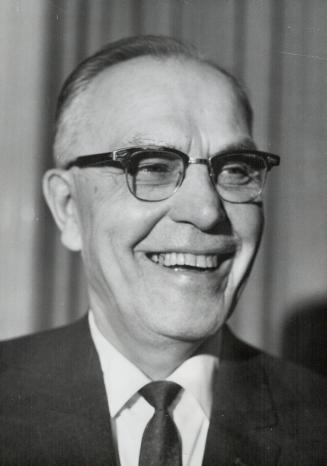 Hap Emms displays smile which justifies nickname as he discusses agreement with Leafs which led to his taking over management of national hockey team