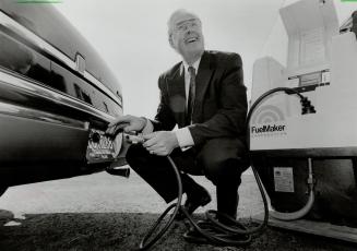 Tanking up: Energy Minister Jake Epp, filling up a natural gas powered car, says investment rules may be changed to help Canada's oil industry expand