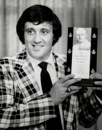 Hockey star Phil Esposito holds the Lou Marsh Trophy, given him last night as Canada's outstanding athlete of 1972